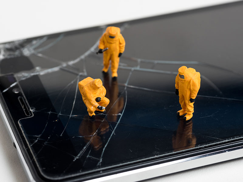 High Angle View Of Figurines On Broken Mobile Phone